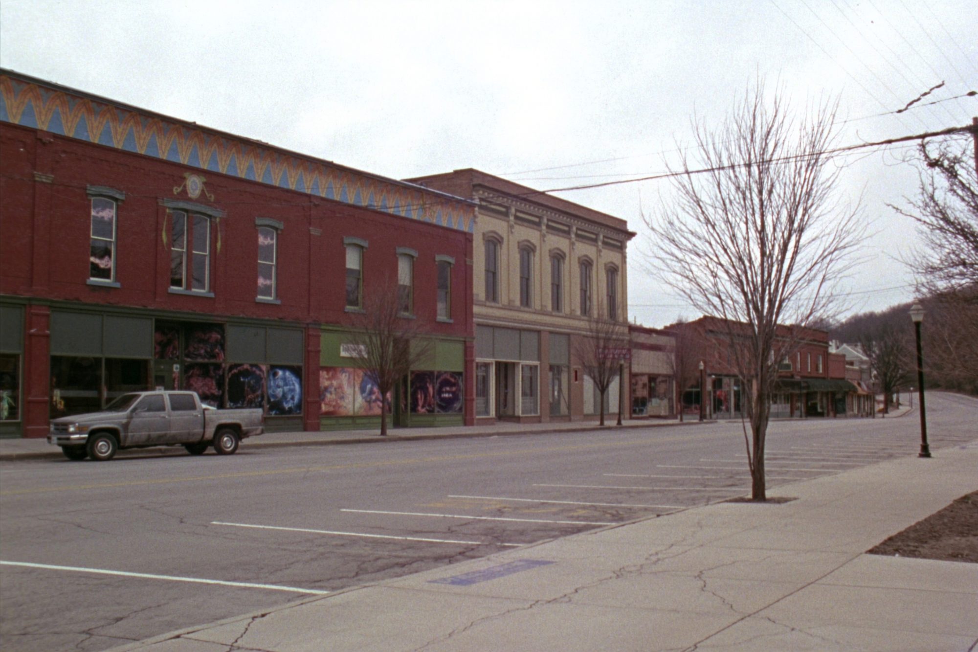 The brick main street of a small Missouri town, nineteenth-century storefronts and angled parking.